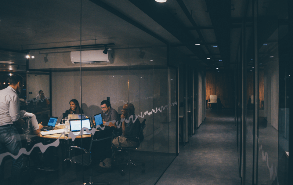 A group of people working in a glass walled room
